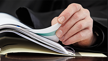 A close up of a hand turning the pages of a document