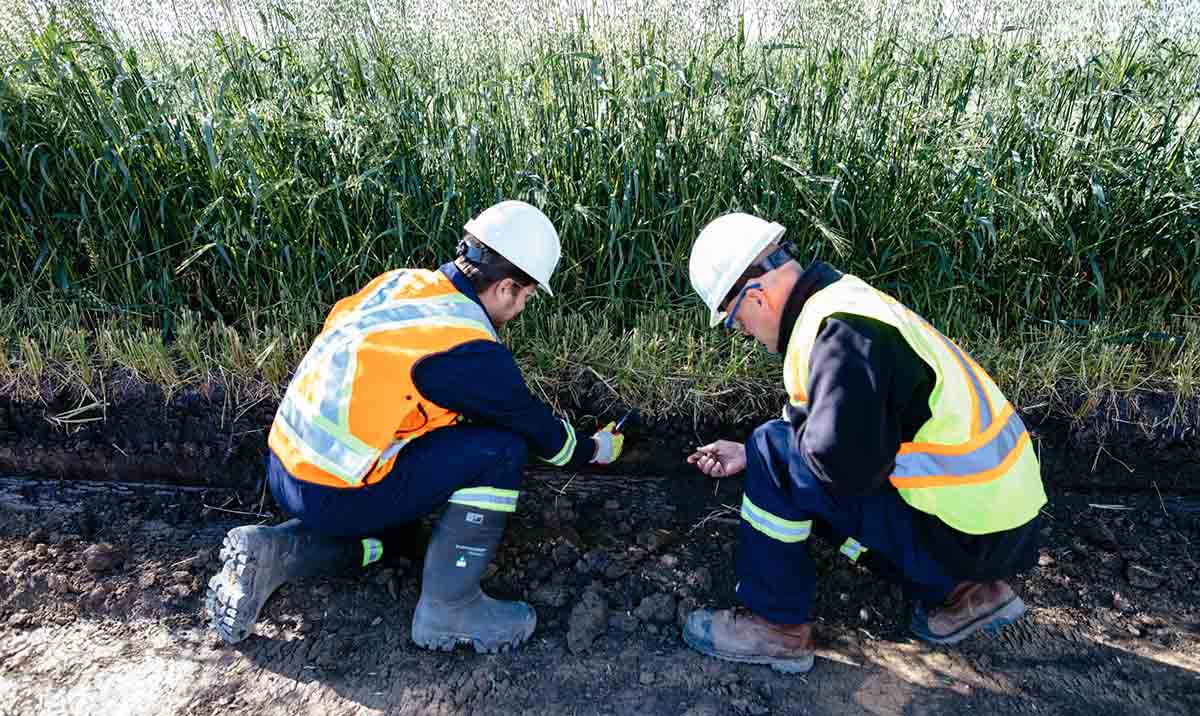 Two CER inspectors kneeling to inspect ground