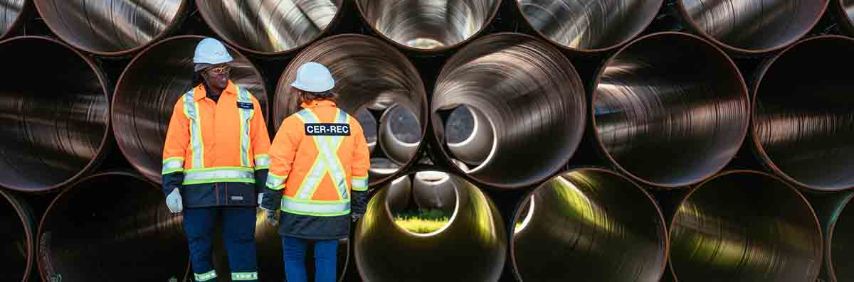 Two CER inspectors standing next to pipe lengths