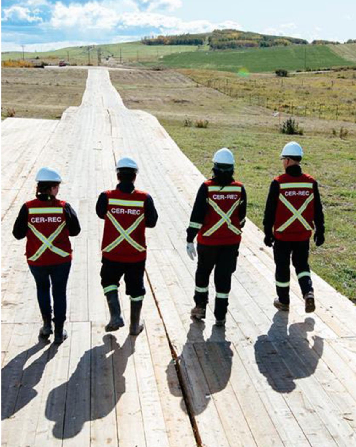Figure 6 – Des inspecteurs de la Régie marchent le long d’un parcours recouvert de planches.