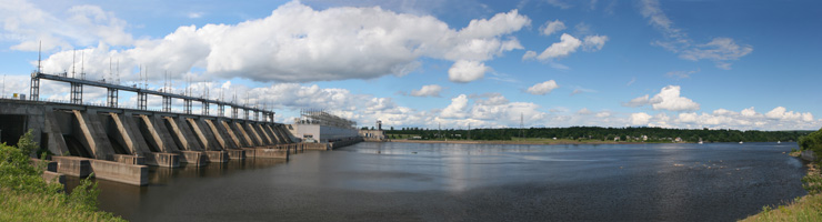 Photo sur la longueur d’un grand barrage hydroélectrique et de son réservoir sous un ciel parsemé de nuages dans l’Est du Canada