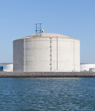 Un réservoir de stockage de gaz naturel liquéfié au terminal de GNL du port de Rotterdam, au Pays-Bas, qui se détache sous un beau ciel bleu