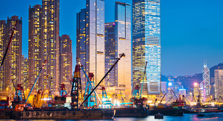 Un cargo apparaît devant la silhouette de la ville de Hong Kong, en Chine, le soit tombé