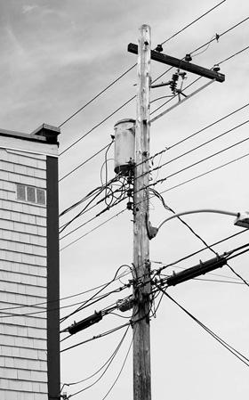 A power line pole stands beside an old building in historic Annapolis Royal, Nova Scotia.