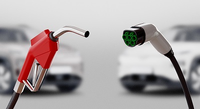 Gas pump and electric vehicle charger with two cars in a blurry background