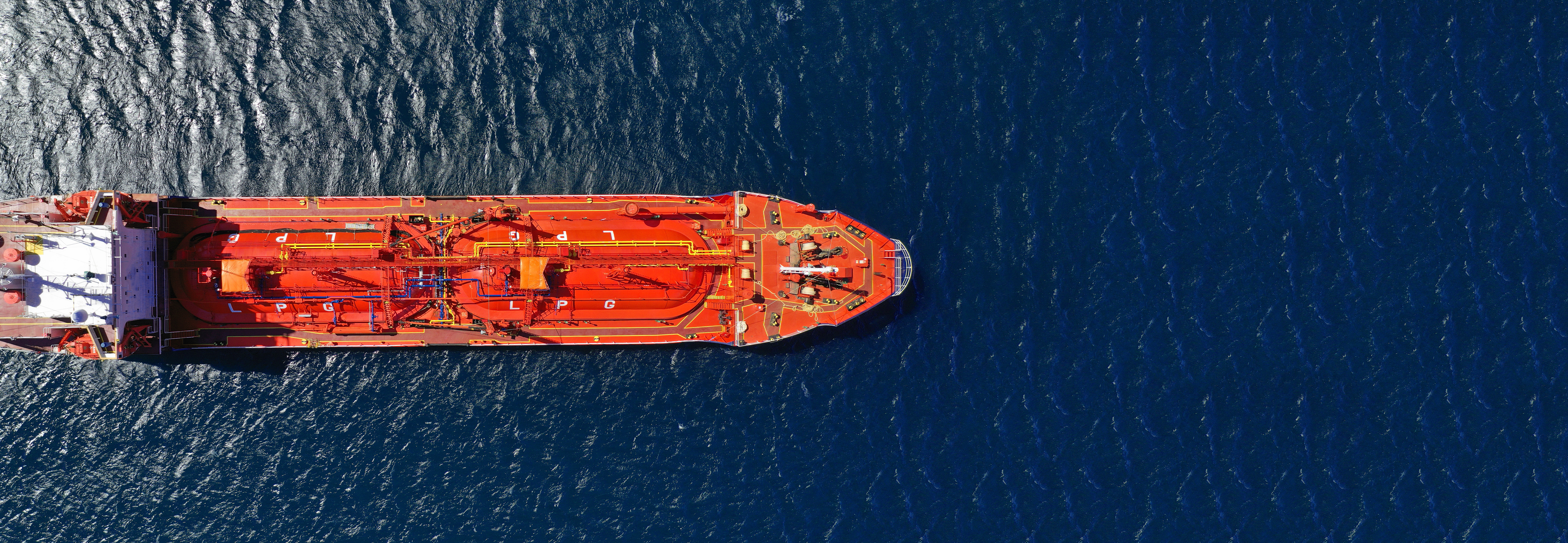 Un navire-citerne transportant du gaz de pétrole liquéfié navigue sur l’océan en plein soleil.